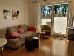ein Wohnzimmer mit einem Sofa und einem Tisch in der Unterkunft Haus am Grömitzer Deich in Grömitz