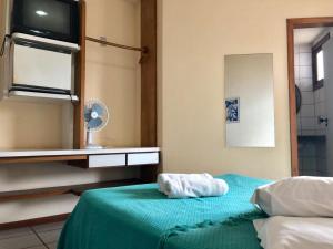 a bedroom with a bed with a towel on it at Pousada da Aldeia in Serra