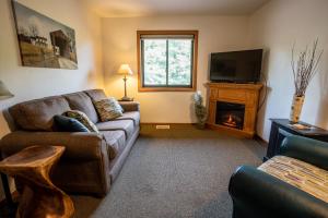 シスター・ベイにあるOpen Hearth Lodgeのソファと暖炉のあるリビングルーム