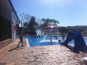 a boy playing in a swimming pool with a slide at Pension Arenas in Ajo