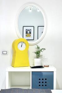 サン・ペッレグリーノ・テルメにあるDesign Suite Cavagnaの時計付きテーブル上鏡