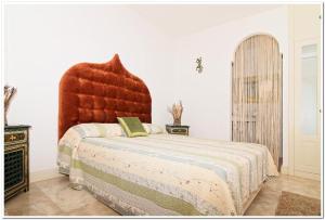 a bedroom with a large bed with a red headboard at Mi casa su casa in La Oliva +15 photos
