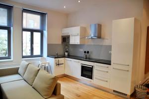 salon z kanapą i kuchnią w obiekcie Family Apartments w Pradze