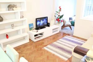 sala de estar con muebles blancos y TV de pantalla plana en Moderno apartamento em Ipanema - PM203 Z1, en Río de Janeiro