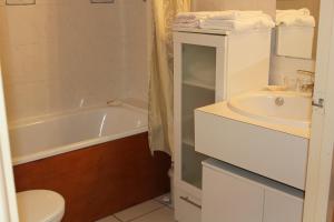 een badkamer met een wastafel, een bad en een toilet bij Anglet face à l'océan in Anglet