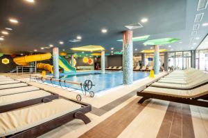 a pool with a slide and beds in a building at HostGost at Kraljevi Čardaci in Kopaonik