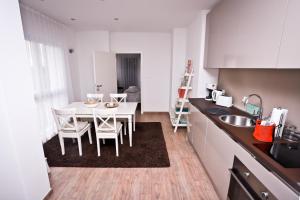 kuchnia ze stołem i krzesłami w pokoju w obiekcie Apartment I&I w Poreču