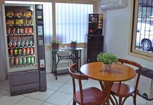 a dining room with a table and a refrigerator at Colossi Hotel in Porto Alegre