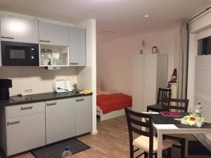 a kitchen and dining room with a table and a room with a bed at Harz-Glück1 in Braunlage