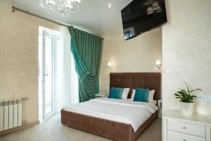 a bedroom with a large bed with a television on the wall at Студия Luxury в центре in Mykolaiv