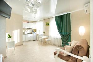 a living room with a couch and a table and a kitchen at Студия Luxury в центре in Mykolaiv