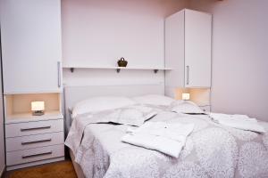 sypialnia z białym łóżkiem i białymi szafkami w obiekcie Apartment I&I w Poreču