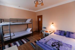 a bedroom with two bunk beds and a table at Samovar Hostel in Vladimir