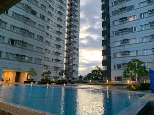 a swimming pool between two tall buildings at Patrick s Place in Davao City