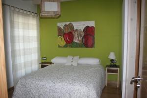 1 dormitorio con 1 cama y una pintura en la pared en Gure Idorpea, en Lesaka