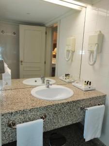 a bathroom with a sink and a mirror at Pousada Barão de Forrester in Alijó