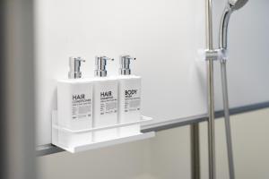 a shelf in a bathroom with three products on it at Kamin Kanazawa in Kanazawa +85 photos