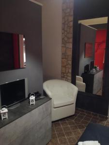 La Casetta Rossa في فروزينوني: غرفة معيشة بها أريكة وتلفزيون