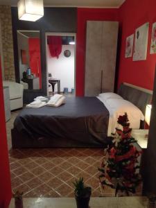 La Casetta Rossa في فروزينوني: غرفة نوم بسرير وشجرة عيد الميلاد