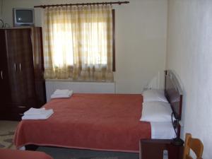 1 dormitorio con cama roja y ventana en Frida, en Antartiko