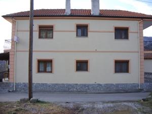 a white building with six windows and a pole at Frida in Antartiko