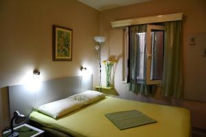 a bedroom with a bed and a window with a vase on it at Apartmani Ćetković in Kotor