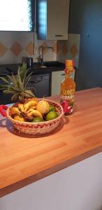 un bol de fruta en una barra con una botella de salsa en Ti Kaz A Rhum, en Sainte-Anne