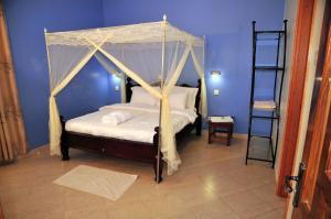 a bedroom with a canopy bed with a ladder at Victoria Lake View Guesthouse & Safaris in Entebbe