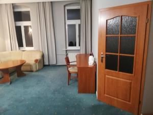 a room with a door and a table and a couch at Hostel Ratuszowy in Bydgoszcz