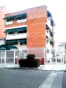 a building with a white fence in front of a building at Hotel Casa Sarita in Bogotá
