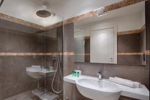 uma casa de banho com 2 lavatórios, um chuveiro e um espelho. em B&B Napoli Time em Nápoles
