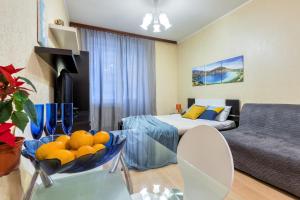 a living room with a bed and a glass table at RentalSPb Studio with balcony in Saint Petersburg