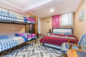 1 dormitorio con 2 literas y sofá en Guest house poligloti en Tʼelavi