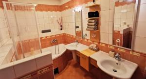 łazienka z 2 umywalkami, wanną i prysznicem w obiekcie Luxusný Dom Donovaly w mieście Donovaly