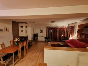ein Wohnzimmer mit einem roten Sofa und einem Tisch in der Unterkunft Luxusný Dom Donovaly in Donovaly