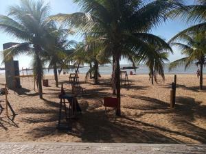 a beach with two palm trees and a playground at Apto Praia de Itapoã 2 qto c/ar in Vila Velha