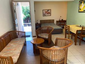 een kamer met stoelen, een bed en een tafel bij Résidence les cactus in Noumea