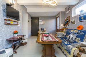 een woonkamer met een bank en een tafel bij Guest house poligloti in Telavi