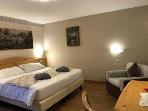 um quarto com uma cama, uma cadeira e uma mesa em Hotel Edelweiss 3 Stelle SUPERIOR em Breuil-Cervinia