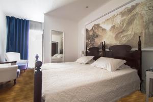 a bedroom with a large bed with a large painting on the wall at Vila Vicência in Funchal