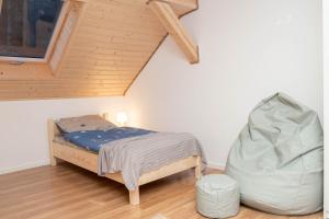 sypialnia z łóżkiem i krzesłem na poddaszu w obiekcie Apartamenty GoszóWita w Stroniu Śląskim