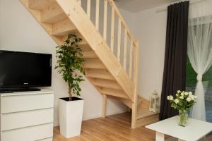 a wooden staircase in a living room with a tv at Apartamenty GoszóWita in Stronie Śląskie