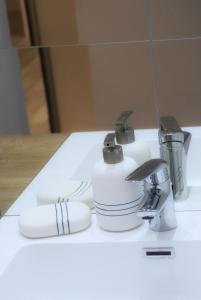 a white sink with two cups and a faucet at Apartment Anna - FREE pickup from OR dropoff to Zagreb airport, please give three days advance notice - EV station - Long-term parking with airport transport possibility in Velika Gorica