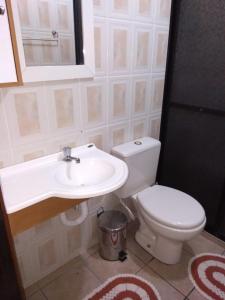 a bathroom with a toilet and a sink at Apartamento "Pé na Areia" Mongaguá in Mongaguá