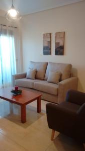 een woonkamer met een bank en een salontafel bij Apartamento primera línea playa d samil in Vigo