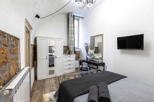 um quarto com uma cama e uma televisão na parede em Casa Patrizia em Orvieto