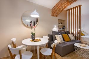a living room with a couch and a table and chairs at Apartments Tivoli in Ljubljana