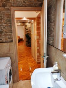 a bathroom with a sink and a toilet and a hallway at V2 with Love - Vintage Modern and Spacious in Belgrade
