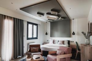 um quarto de hotel com uma cama e uma cadeira em Noelle Mountain Suites em Kalavrita