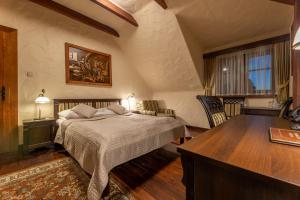 a bedroom with a bed and a desk at Hotel Stanica Kresowa Chreptiów in Lutowiska